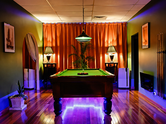 A softly lit rooftop lounge terrace overlooking the city skyline at night.